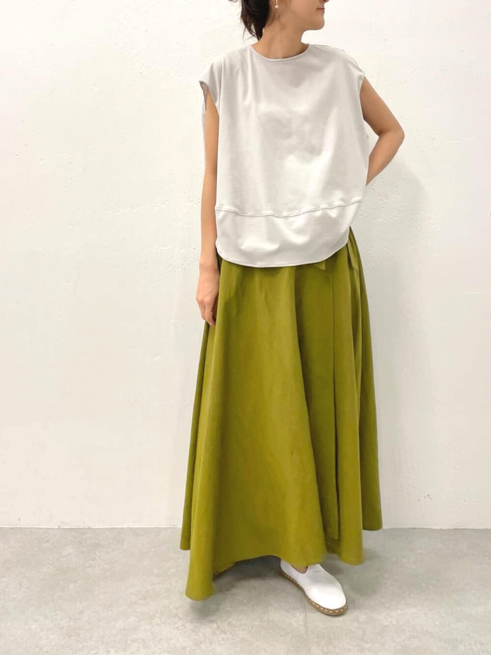 グレー系のTシャツ/カットソー、イエロー系のスカートを着用したレディースの春コーディネートの3枚目の写真