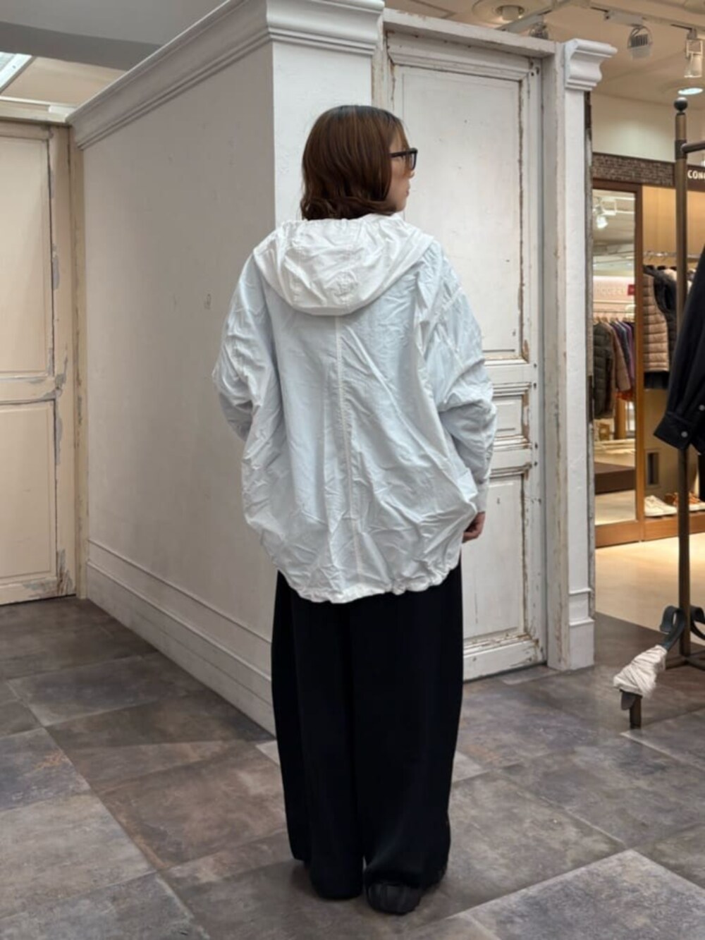 ホワイト系のブルゾン、ブラック系のその他パンツを着用したレディースの冬コーディネートの3枚目の写真