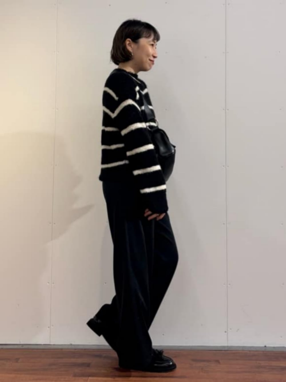 ブラック系のニット/セーター、ブラック系のその他パンツを着用したレディースの秋コーディネートの2枚目の写真