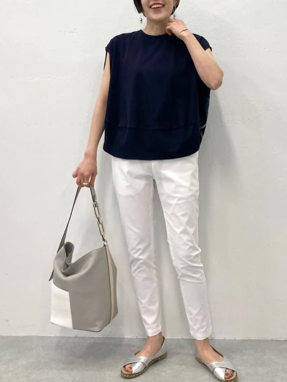 ブルー系のTシャツ/カットソー、ホワイト系のその他パンツ、グレー系のトートバッグを着用したレディースの春コーディネートの3枚目の写真