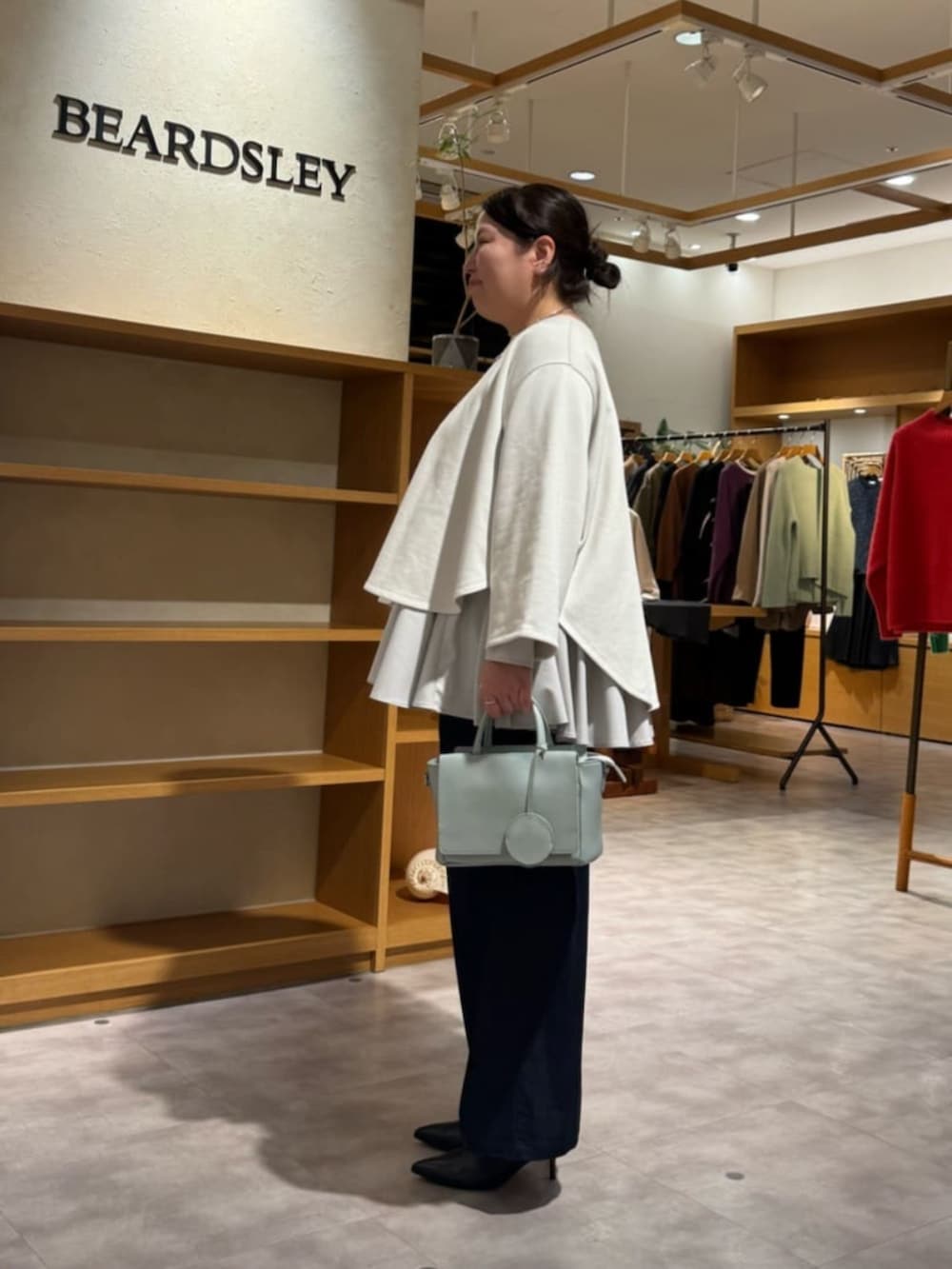 ブルー系のその他パンツ、グリーン系のハンドバッグ、ホワイト系のTシャツ/カットソーを着用したレディースの冬コーディネートの3枚目の写真