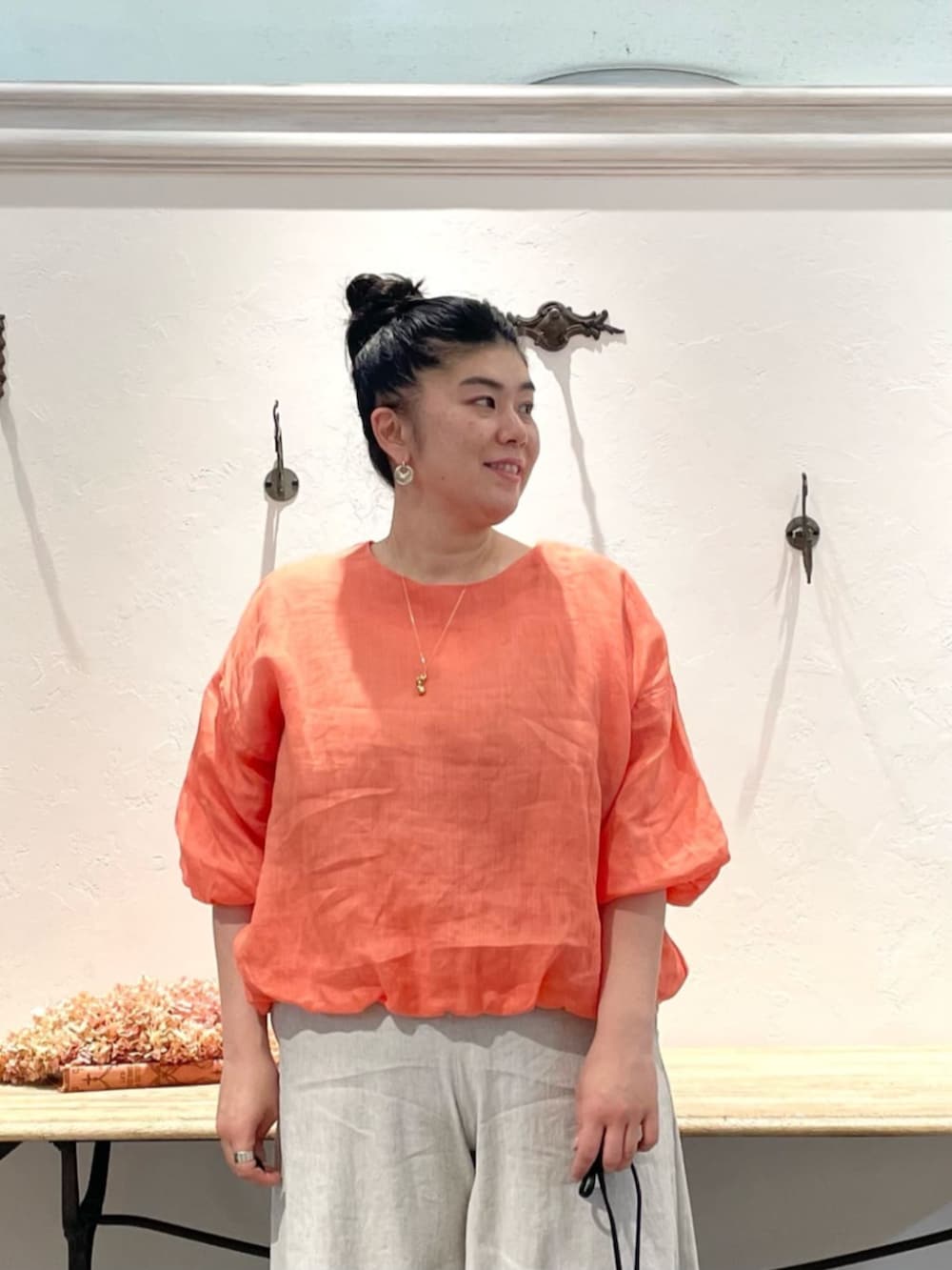 ベージュ系のその他パンツ、オレンジ系のシャツ/ブラウス、ゴールド系のリングを着用したレディースの春コーディネートの4枚目の写真