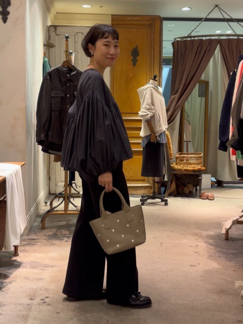 グレー系のトートバッグ、ブラック系のその他パンツ、グレー系のシャツ/ブラウスを着用したレディースの冬コーディネートの3枚目の写真