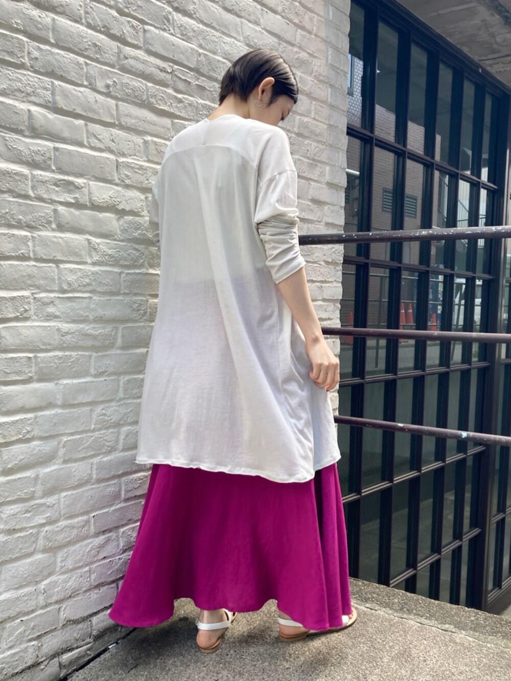 ピンク系のスカート、ベージュ系のカーディガン/ボレロ、ベージュ系のTシャツ/カットソーを着用したレディースの春コーディネートの2枚目の写真