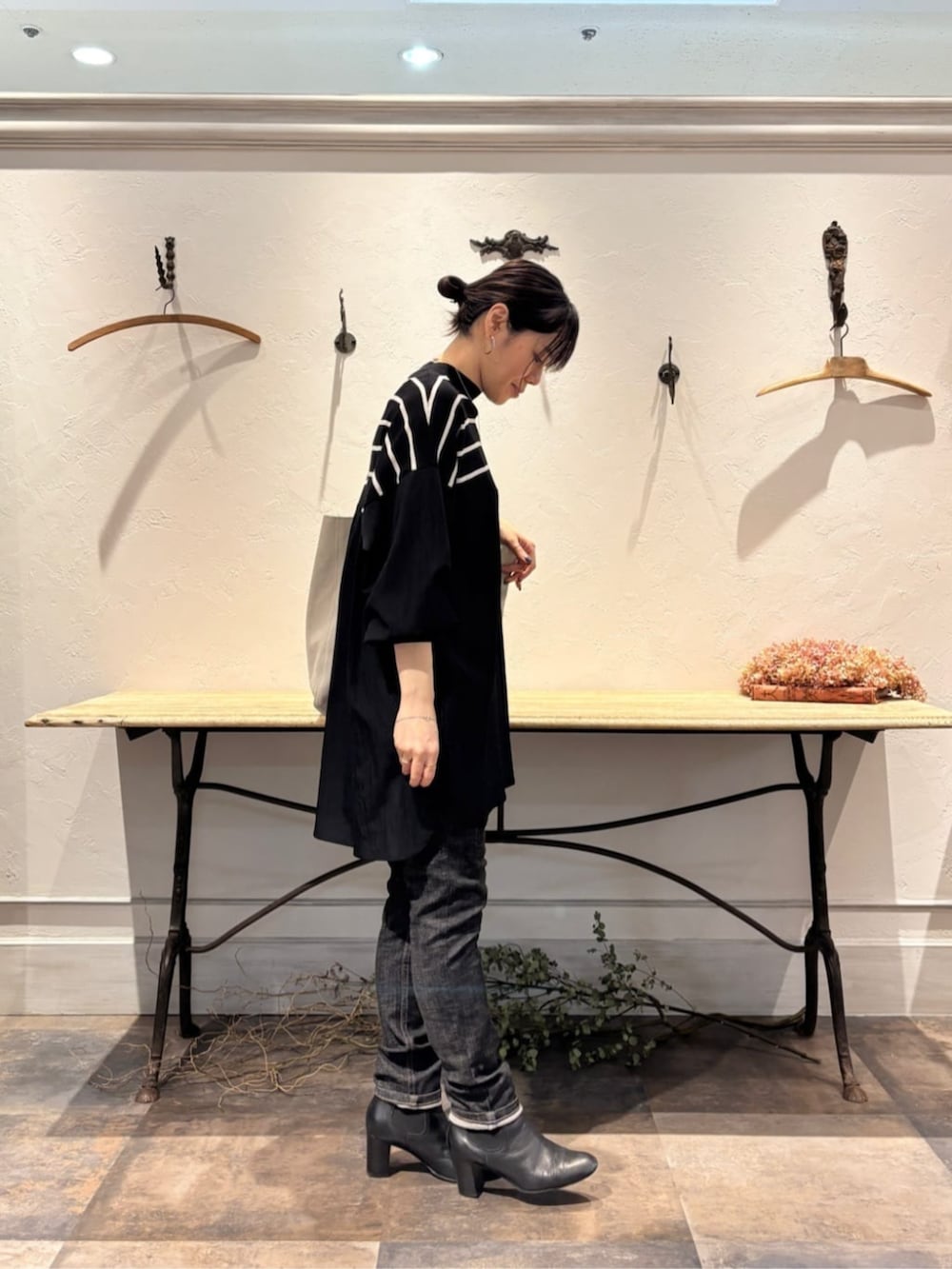 ブラック系のデニムパンツ、ブラック系のニット/セーターを着用したレディースの冬コーディネートの2枚目の写真