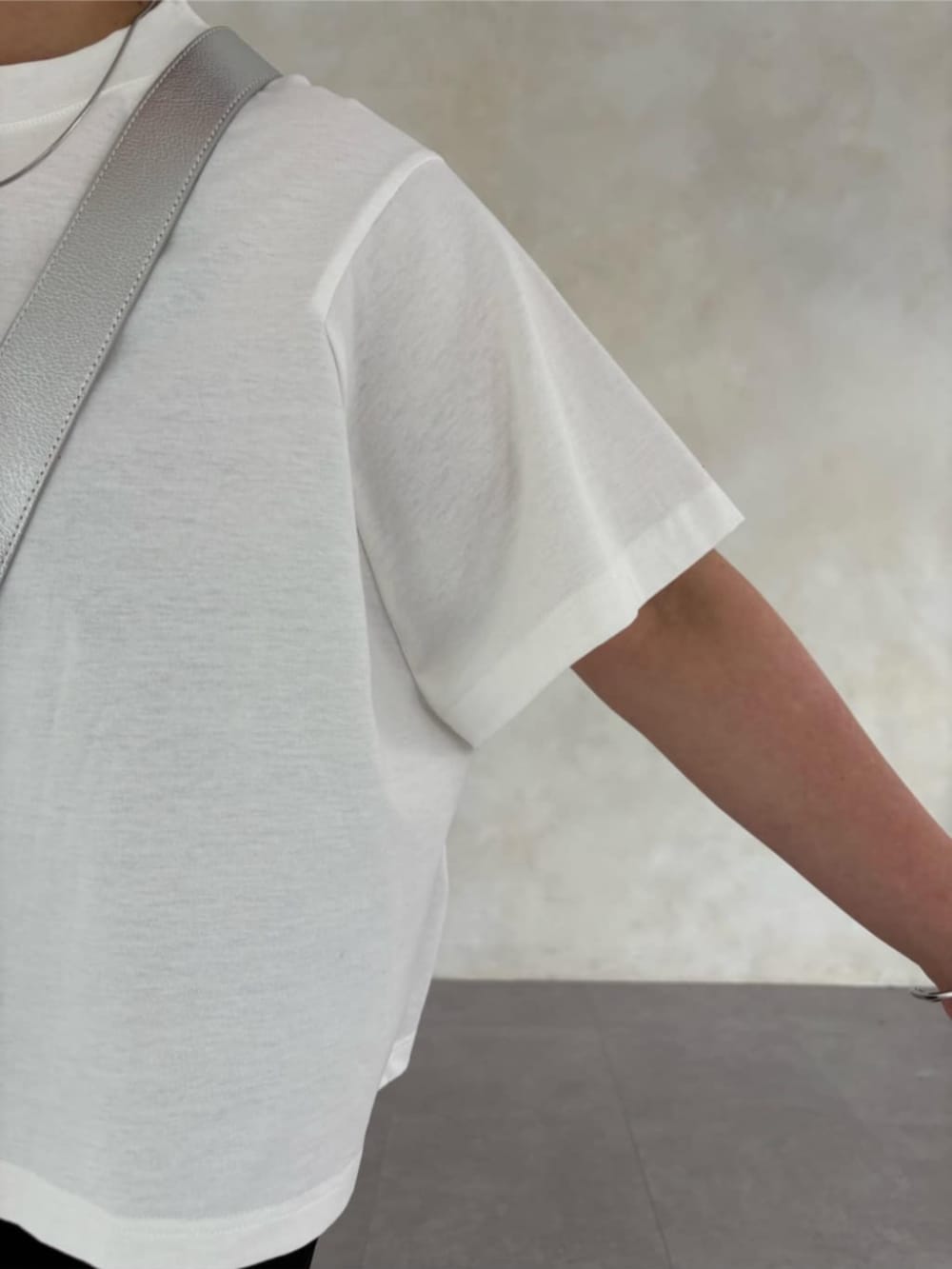 シルバー系のショルダーバッグ、ホワイト系のTシャツ/カットソー、ホワイト系のスニーカーを着用したレディースの春コーディネートの4枚目の写真