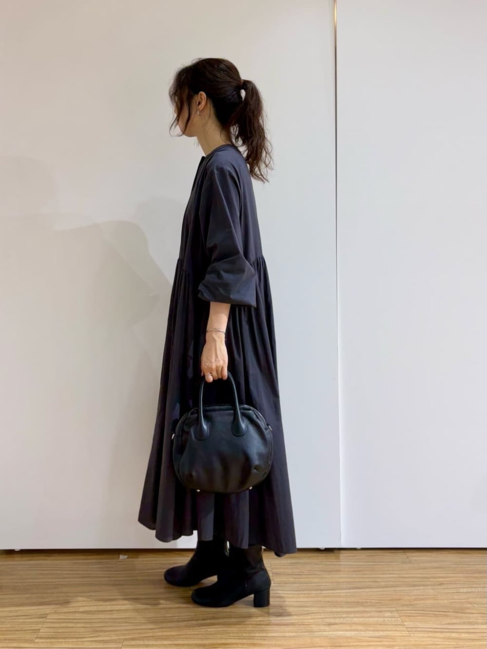 グレー系のワンピースを着用したレディースの冬コーディネートの2枚目の写真