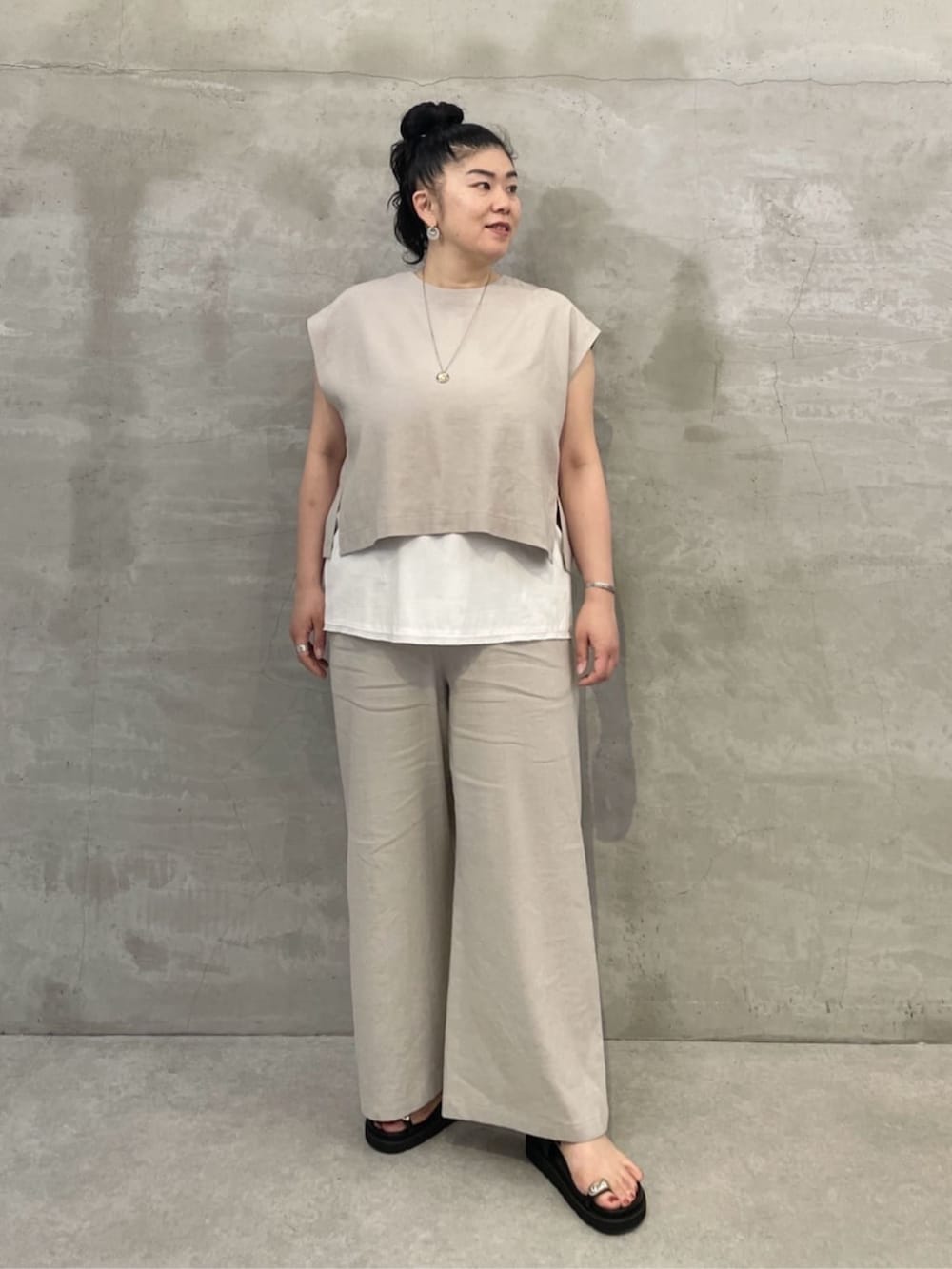 ホワイト系のタンクトップ、ブラック系のショルダーバッグ、ブラック系のサンダルを着用したレディースの春コーディネートの3枚目の写真