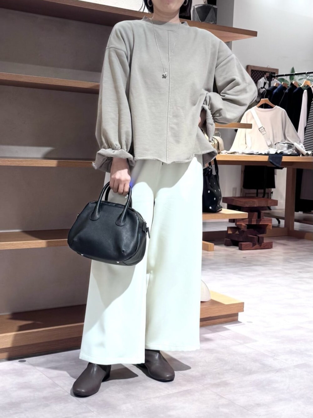 ブラック系のボストンバッグ、ブラウン系のTシャツ/カットソー、ホワイト系のその他パンツを着用したレディースの冬コーディネートの9枚目の写真