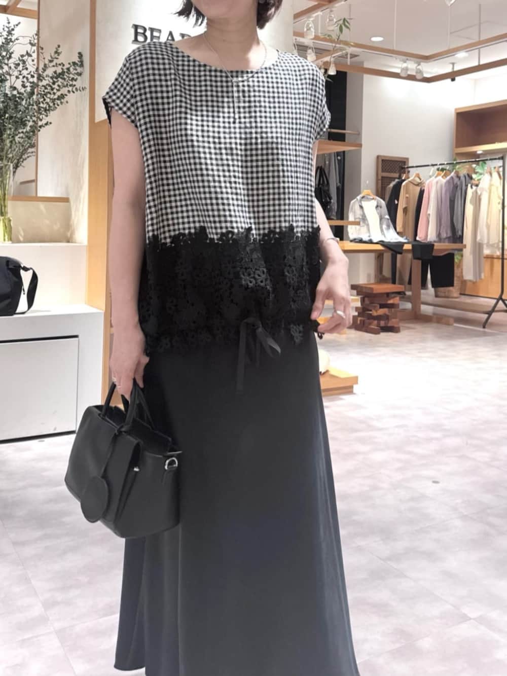 ブラック系のスカート、ブラック系のハンドバッグ、ブラック系のシャツ/ブラウスを着用したレディースの春コーディネートの8枚目の写真