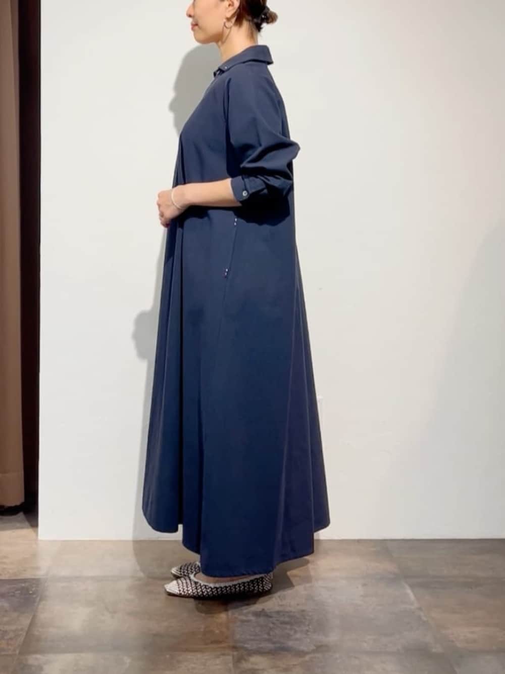 ホワイト系のトートバッグ、ブルー系のワンピースを着用したレディースの春コーディネートの3枚目の写真