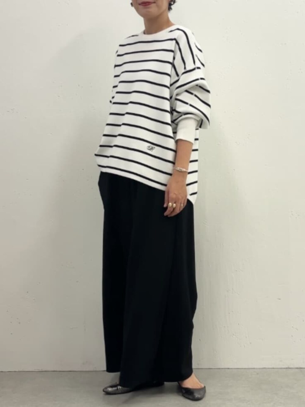 ホワイト系のノーカラージャケット、ブラック系のその他パンツ、ホワイト系のニット/セーターを着用したレディースの冬コーディネートの7枚目の写真