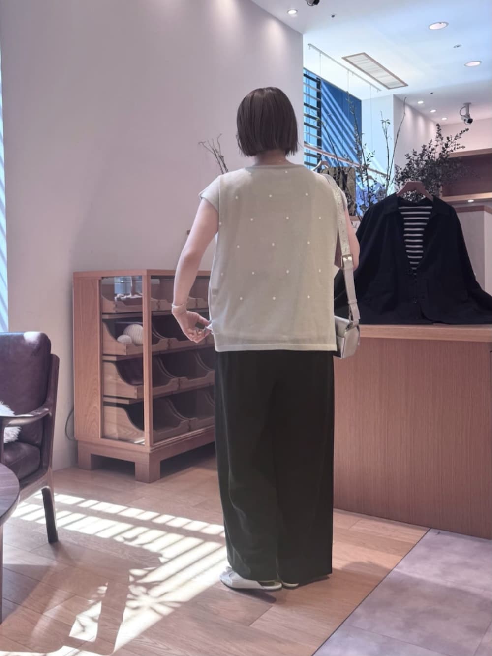 シルバー系のショルダーバッグ、ブラック系のその他パンツ、グレー系のニット/セーターを着用したレディースの春コーディネートの3枚目の写真