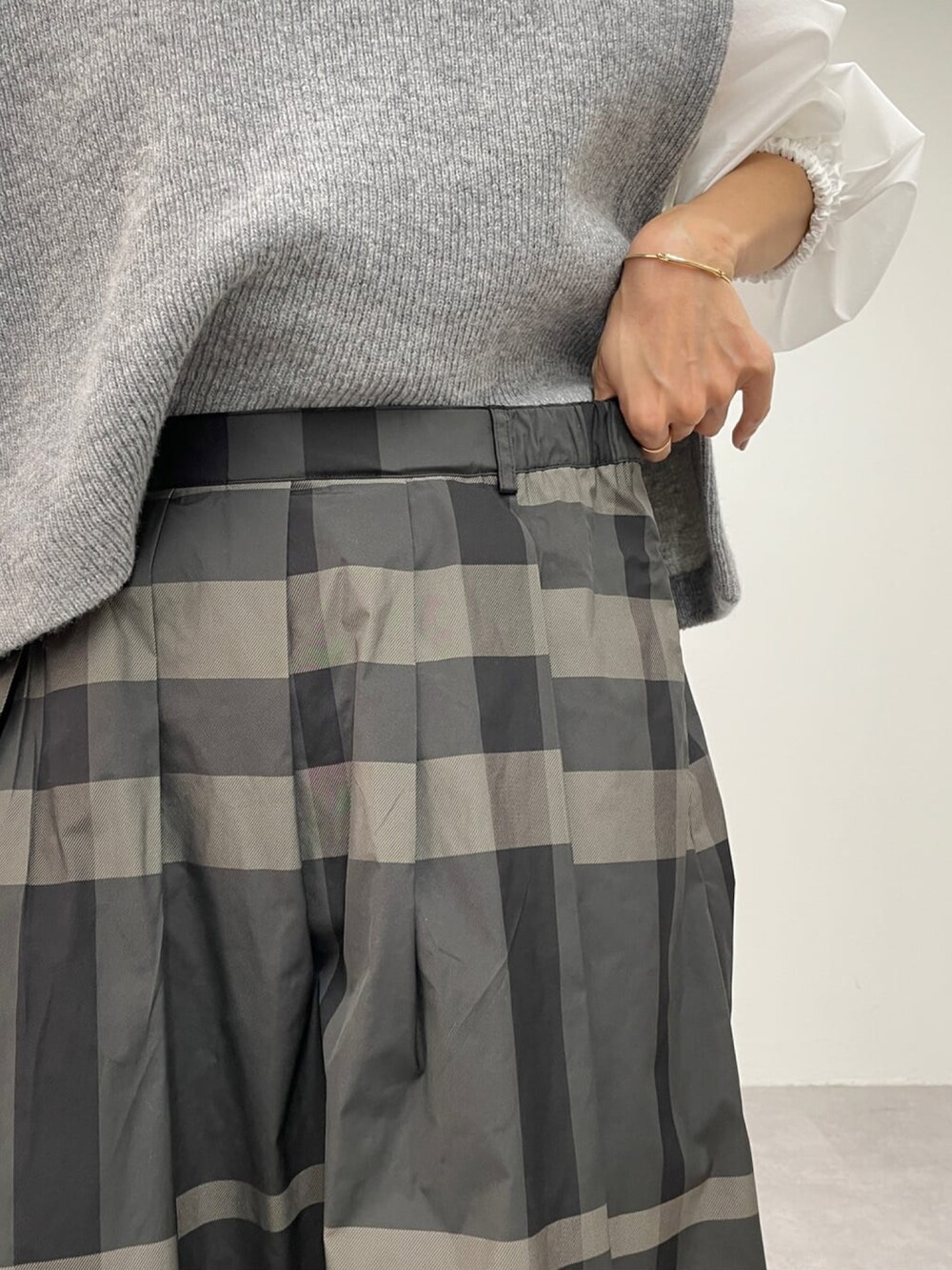 グレー系のスカート、ブラック系のブーツを着用したレディースの冬コーディネートの3枚目の写真