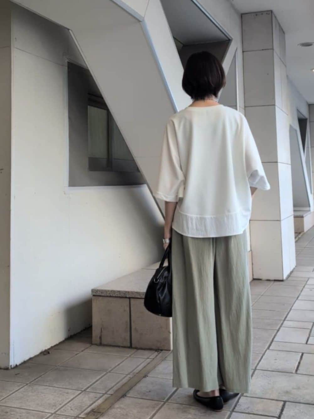 ブラック系のボストンバッグ、グリーン系のその他パンツ、ホワイト系のTシャツ/カットソーを着用したレディースの春コーディネートの7枚目の写真