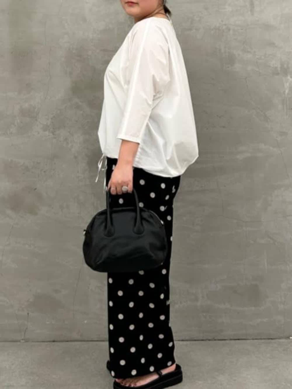 ブラック系のボストンバッグ、ホワイト系のシャツ/ブラウス、ブラック系のその他パンツを着用したレディースの冬コーディネートの5枚目の写真