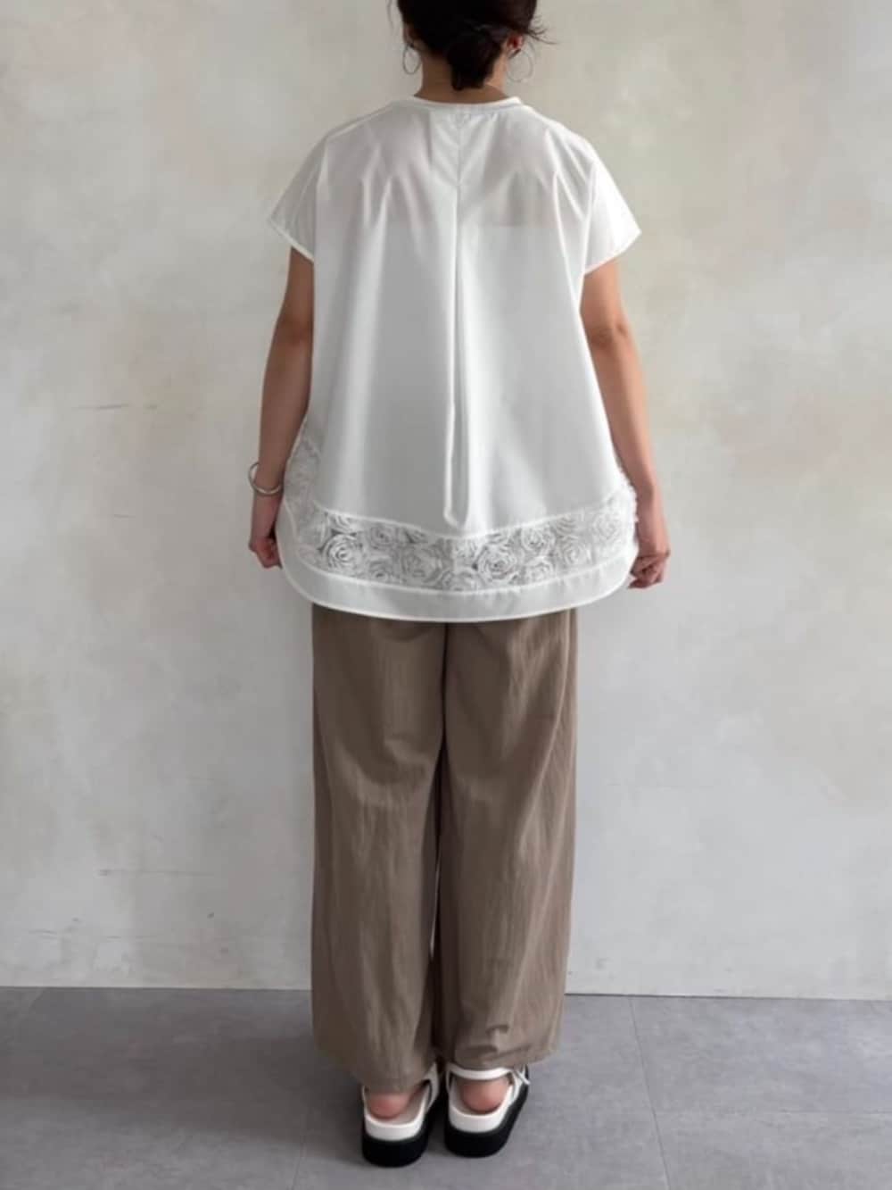 ベージュ系のその他パンツ、ホワイト系のサンダル、ホワイト系のTシャツ/カットソーを着用したレディースの春コーディネートの4枚目の写真
