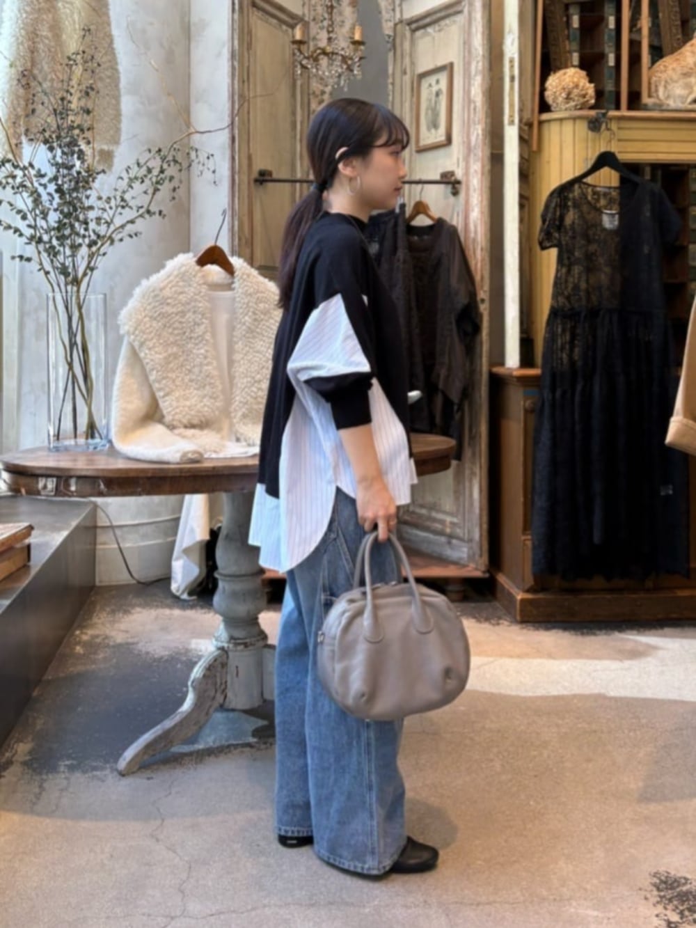 ブルー系のデニムパンツ、ブラック系のニット/セーターを着用したレディースの秋コーディネートの4枚目の写真