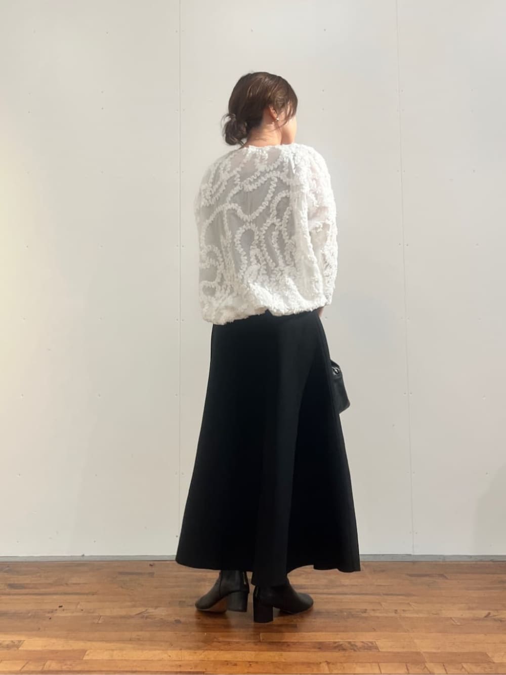 ブラック系のボストンバッグ、ブラック系のスカート、ホワイト系のシャツ/ブラウスを着用したレディースの夏コーディネートの3枚目の写真
