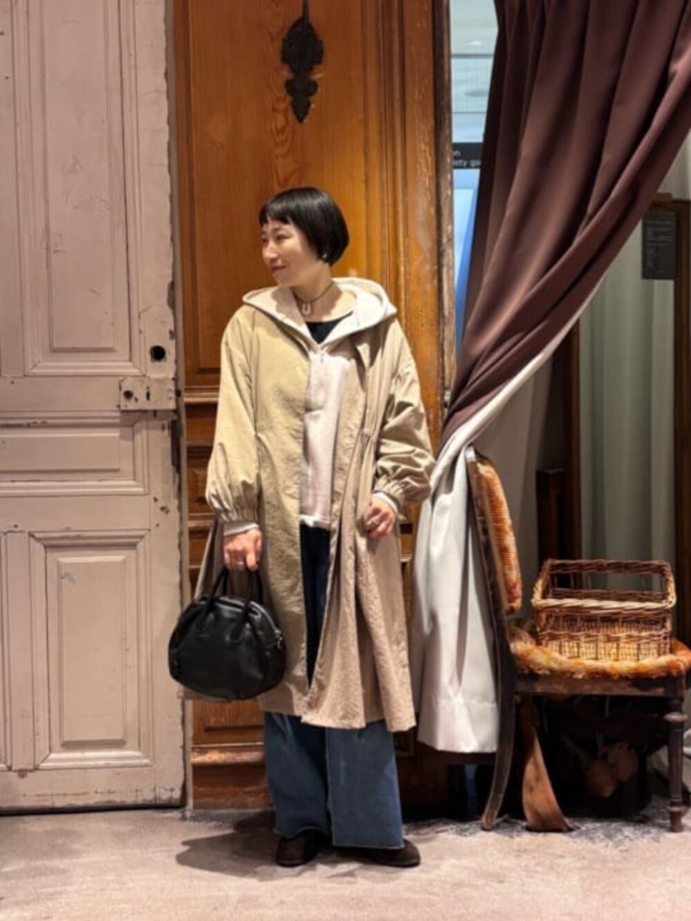 ベージュ系のその他アウター、ブラック系のボストンバッグ、ホワイト系のパーカーを着用したレディースの冬コーディネートの3枚目の写真