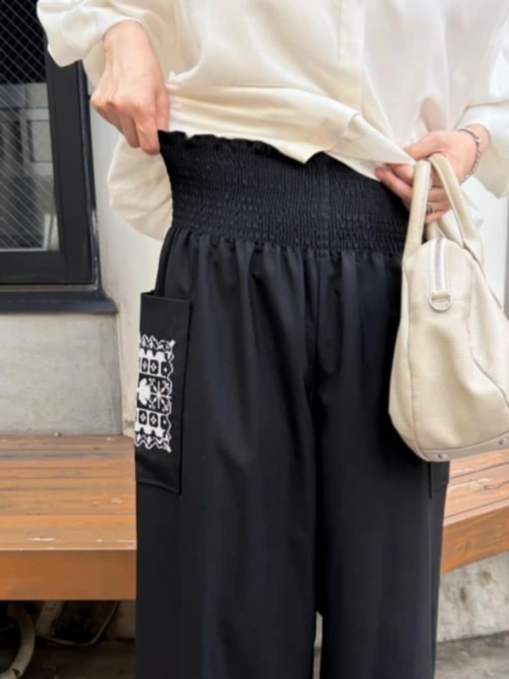 ホワイト系のシャツ/ブラウス、ブラック系のその他パンツ、ブラック系のブーツを着用したレディースの秋コーディネートの9枚目の写真
