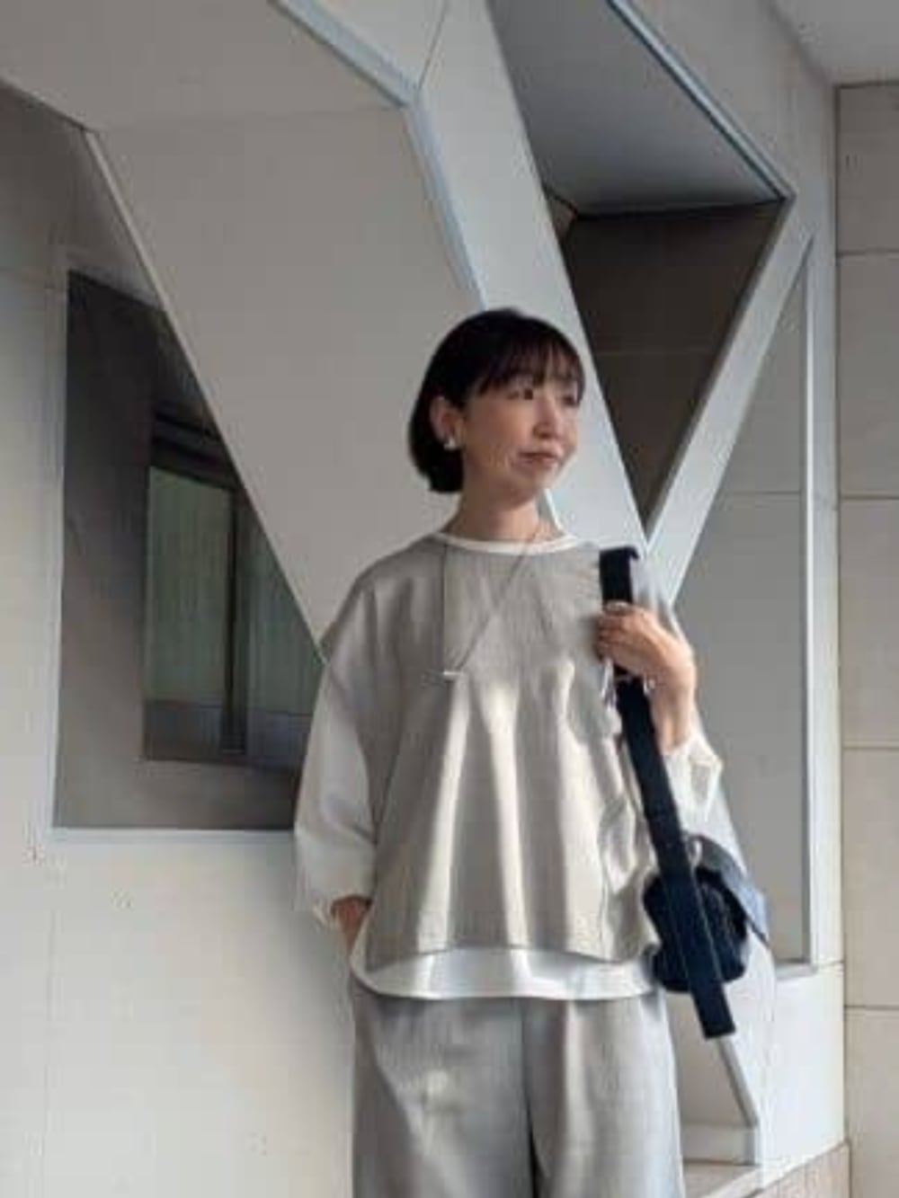 グレー系のシャツ/ブラウス、ホワイト系のシャツ/ブラウス、ブラック系のショルダーバッグを着用したレディースの春コーディネートの4枚目の写真