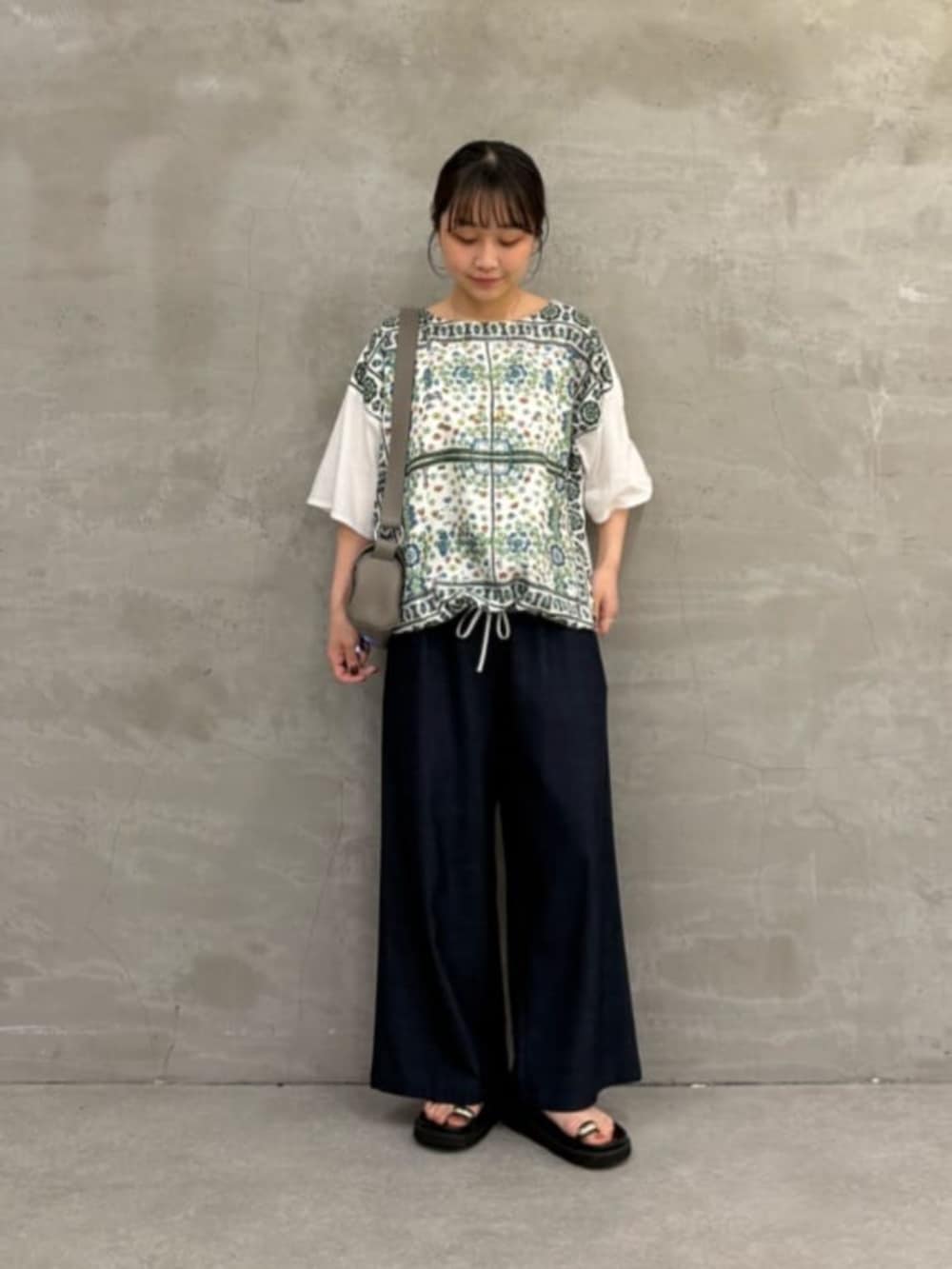 ブラック系のサンダル、ホワイト系のTシャツ/カットソーを着用したレディースの春コーディネートの3枚目の写真