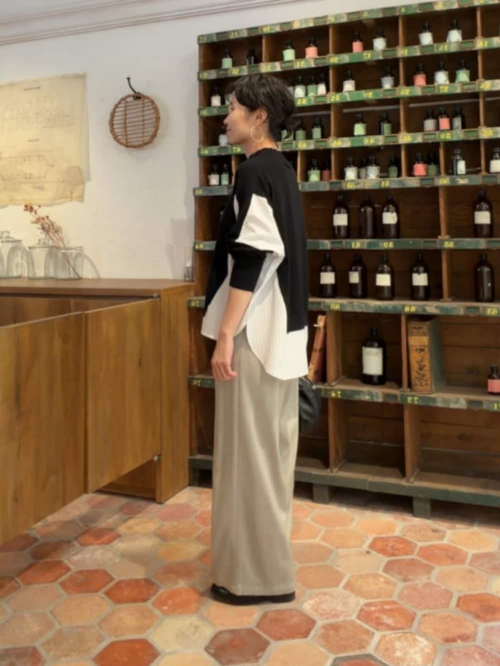 グレー系のその他パンツ、ブラック系のニット/セーターを着用したレディースの秋コーディネートの2枚目の写真