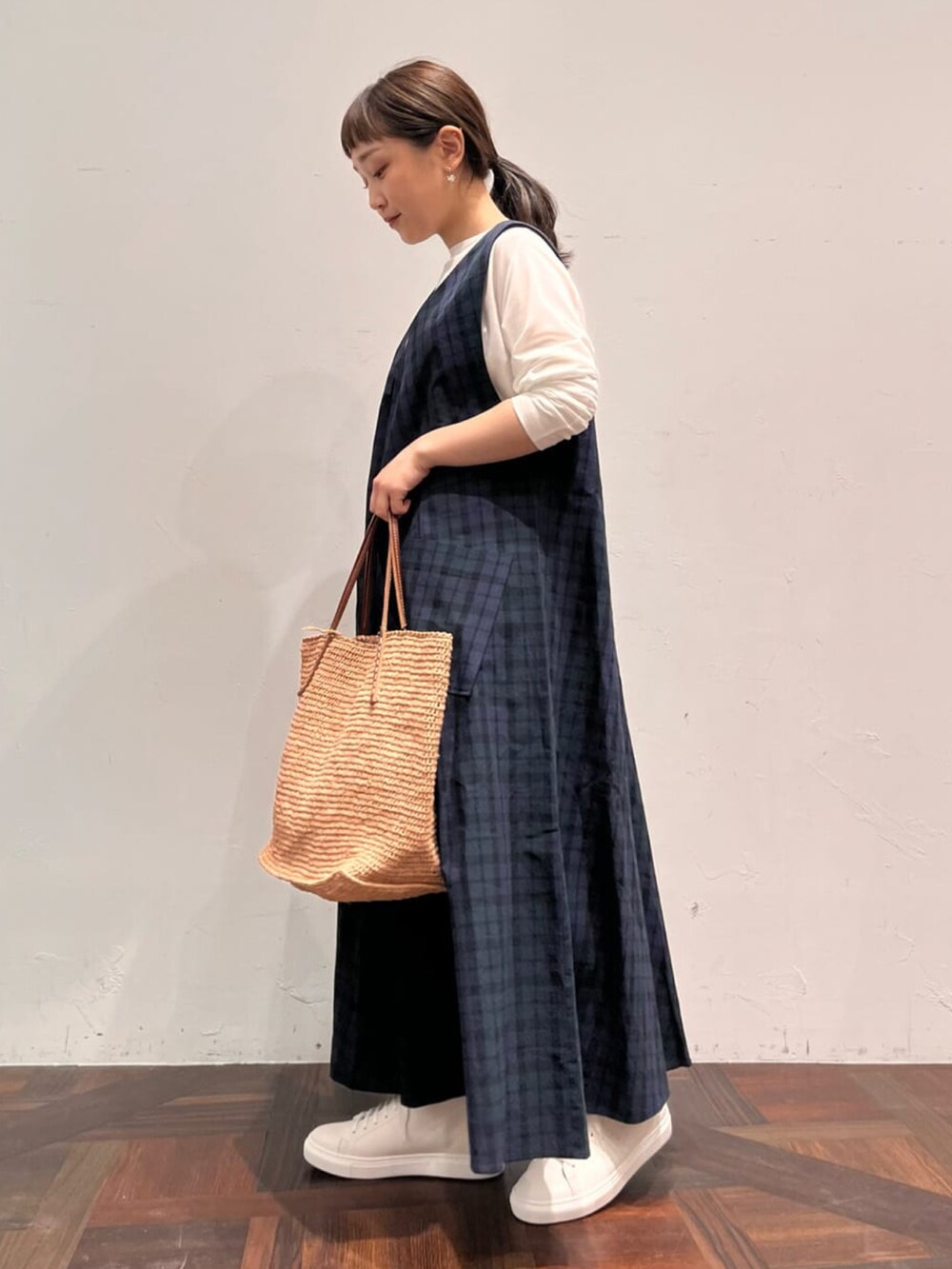 ブルー系のワンピース、ホワイト系のTシャツ/カットソー、ベージュ系のかごバッグを着用したレディースの春コーディネートの2枚目の写真