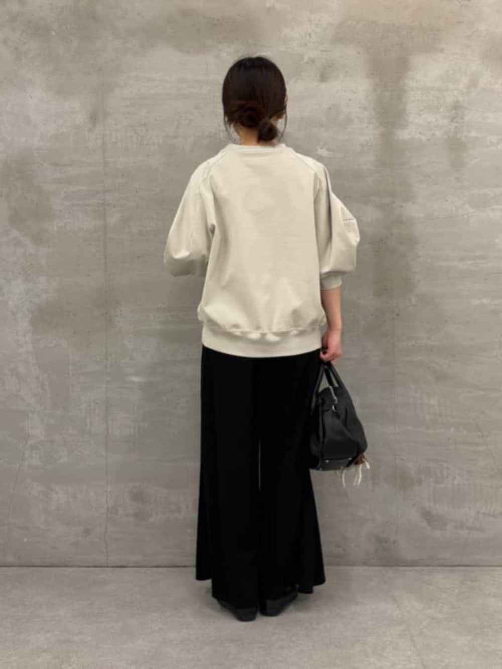 ブラック系のボストンバッグ、ブラック系のその他パンツ、グレー系のTシャツ/カットソーを着用したレディースの冬コーディネートの6枚目の写真