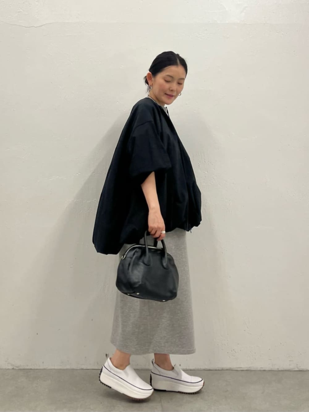 ブラック系のブルゾン、グレー系のワンピースを着用したレディースの冬コーディネートの3枚目の写真