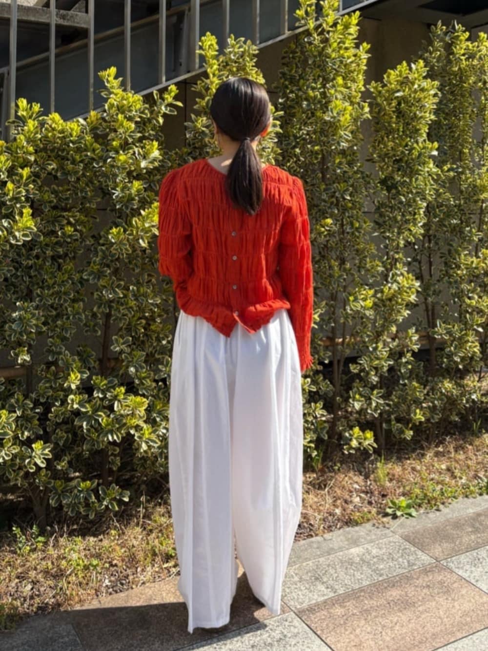 オレンジ系のシャツ/ブラウス、ホワイト系のその他パンツを着用したレディースの春コーディネートの5枚目の写真