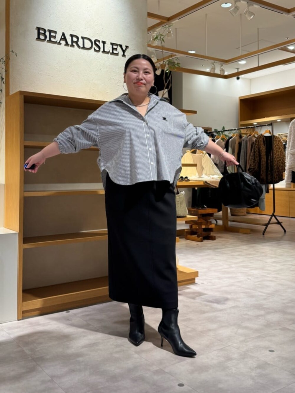 ブラック系のブーツ、ブルー系のシャツ/ブラウスを着用したレディースの冬コーディネートの2枚目の写真