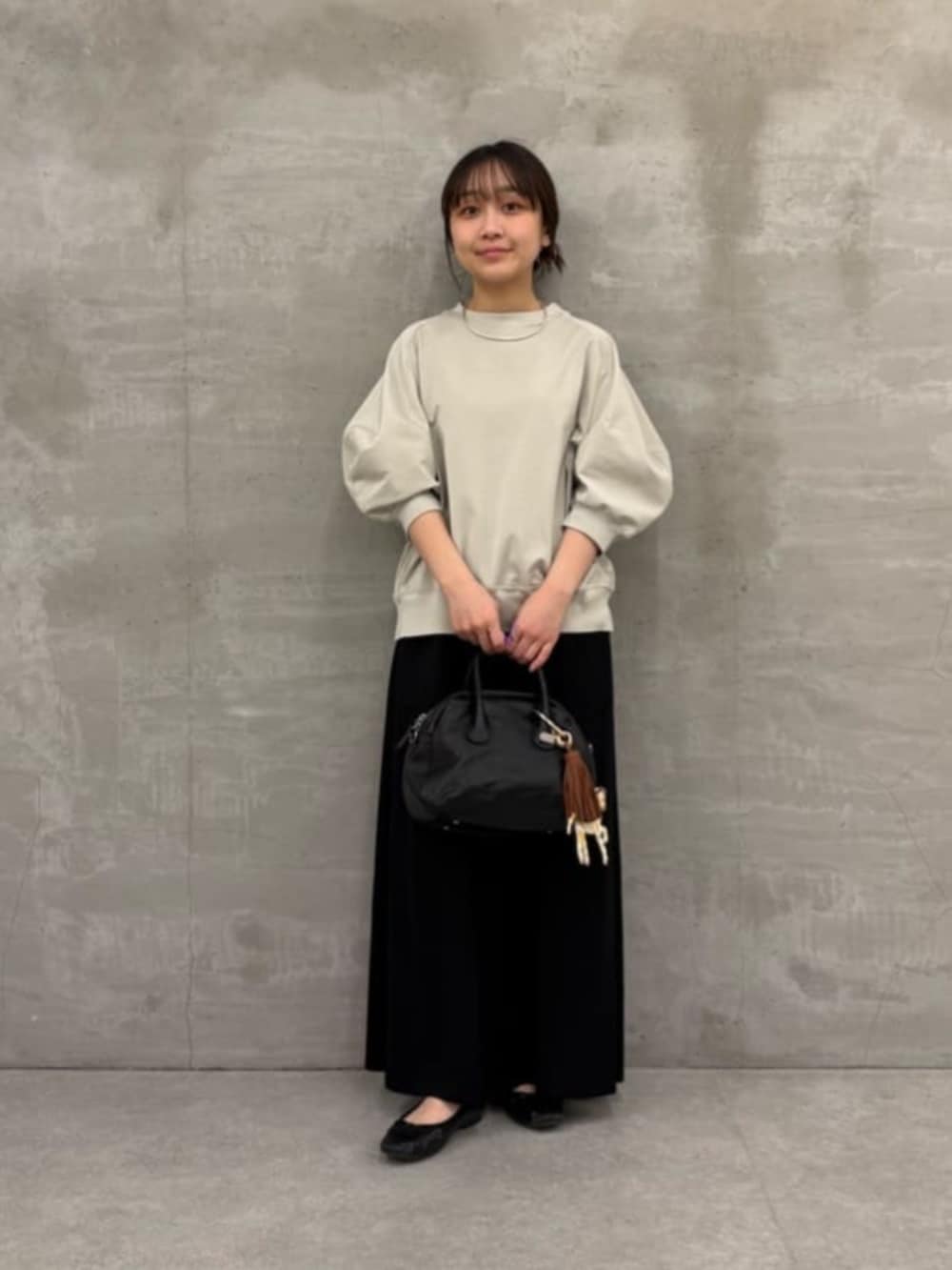 ブラック系のボストンバッグ、ブラック系のその他パンツ、グレー系のTシャツ/カットソーを着用したレディースの冬コーディネートの3枚目の写真