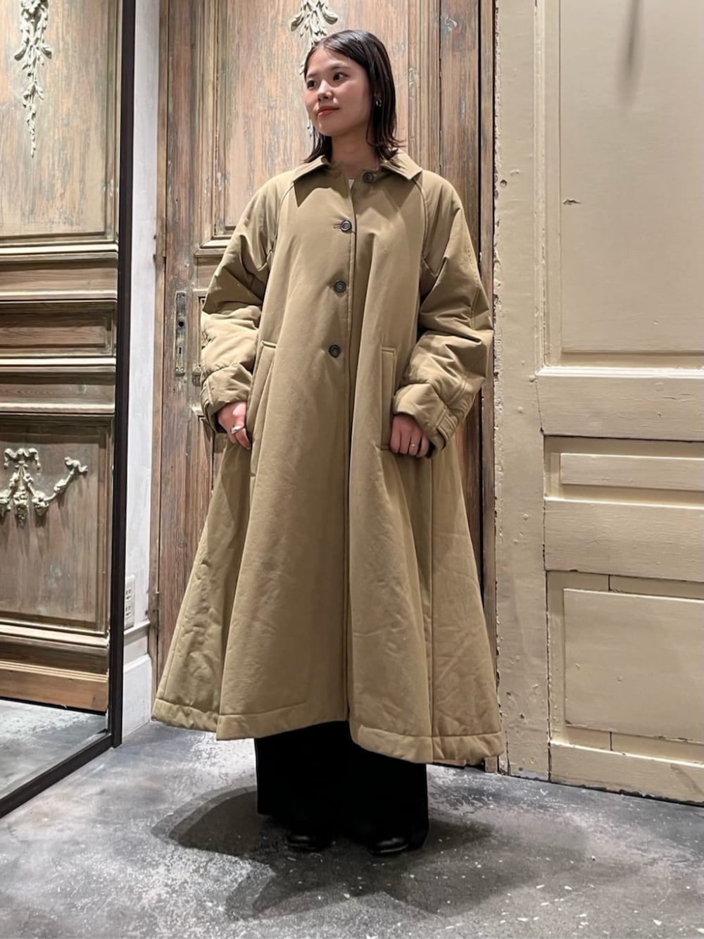 ブラック系のショルダーバッグ、イエロー系のその他アウター、ブラック系のチャームを着用したレディースの冬コーディネートの3枚目の写真