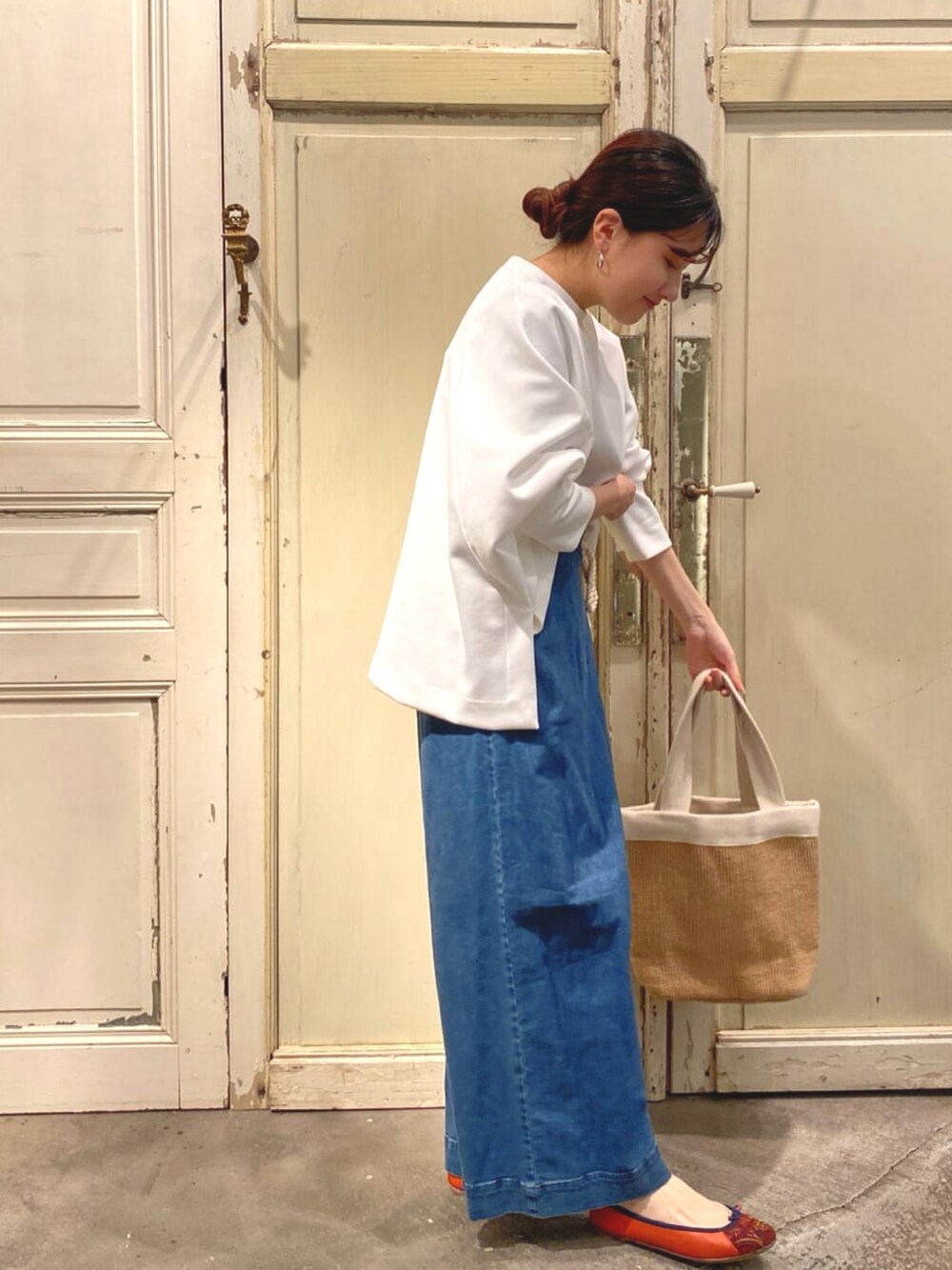 ブルー系のデニムパンツ、ホワイト系のTシャツ/カットソー、ホワイト系のトートバッグを着用したレディースの冬コーディネートの2枚目の写真