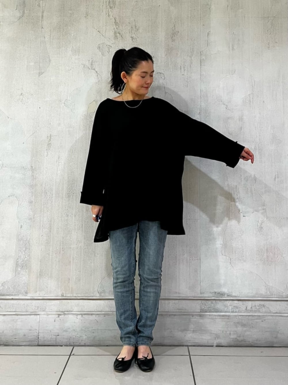 ブルー系のデニムパンツ、ブラック系のハンドバッグ、ブラック系のTシャツ/カットソーを着用したレディースの春コーディネートの7枚目の写真