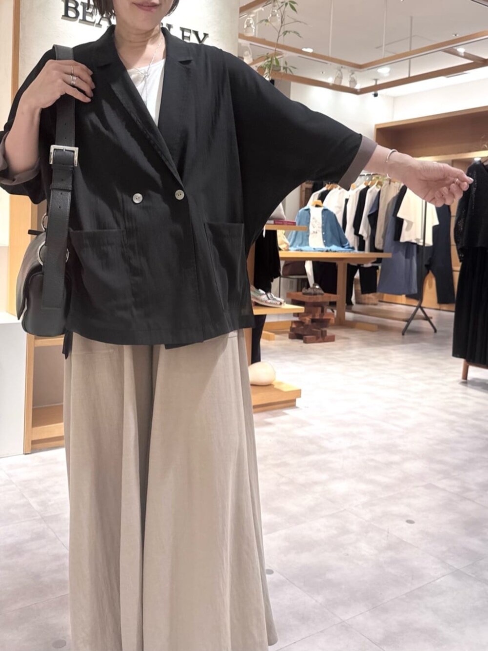 ブラック系のテーラードジャケット、ベージュ系のその他パンツ、ホワイト系のサンダルを着用したレディースの春コーディネートの9枚目の写真