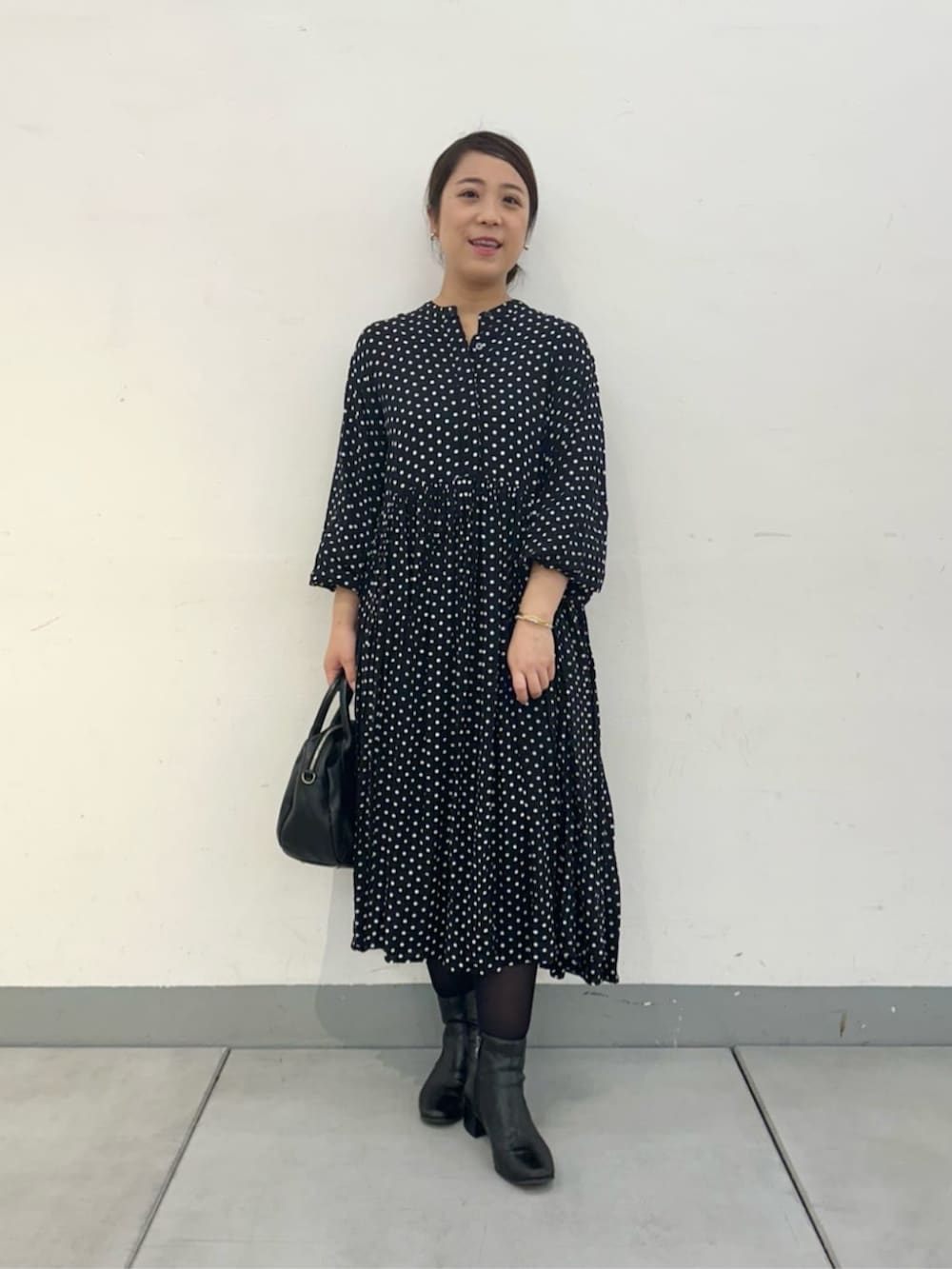 ベージュ系のその他アウター、ブラック系のワンピースを着用したレディースの冬コーディネートの5枚目の写真