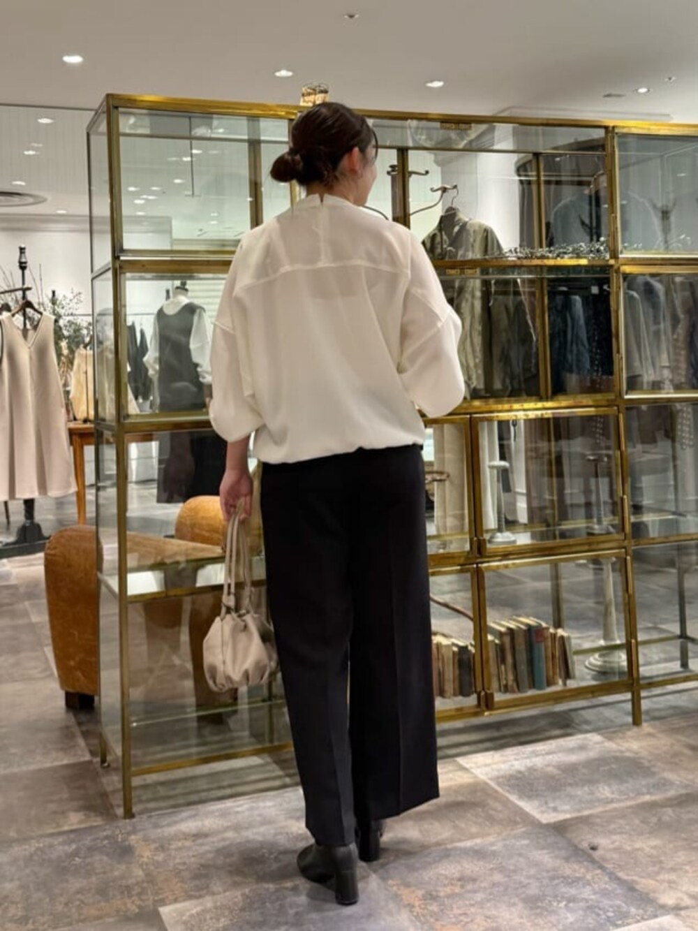 ベージュ系のショルダーバッグ、ホワイト系のシャツ/ブラウス、ブラック系のその他パンツを着用したレディースの冬コーディネートの3枚目の写真