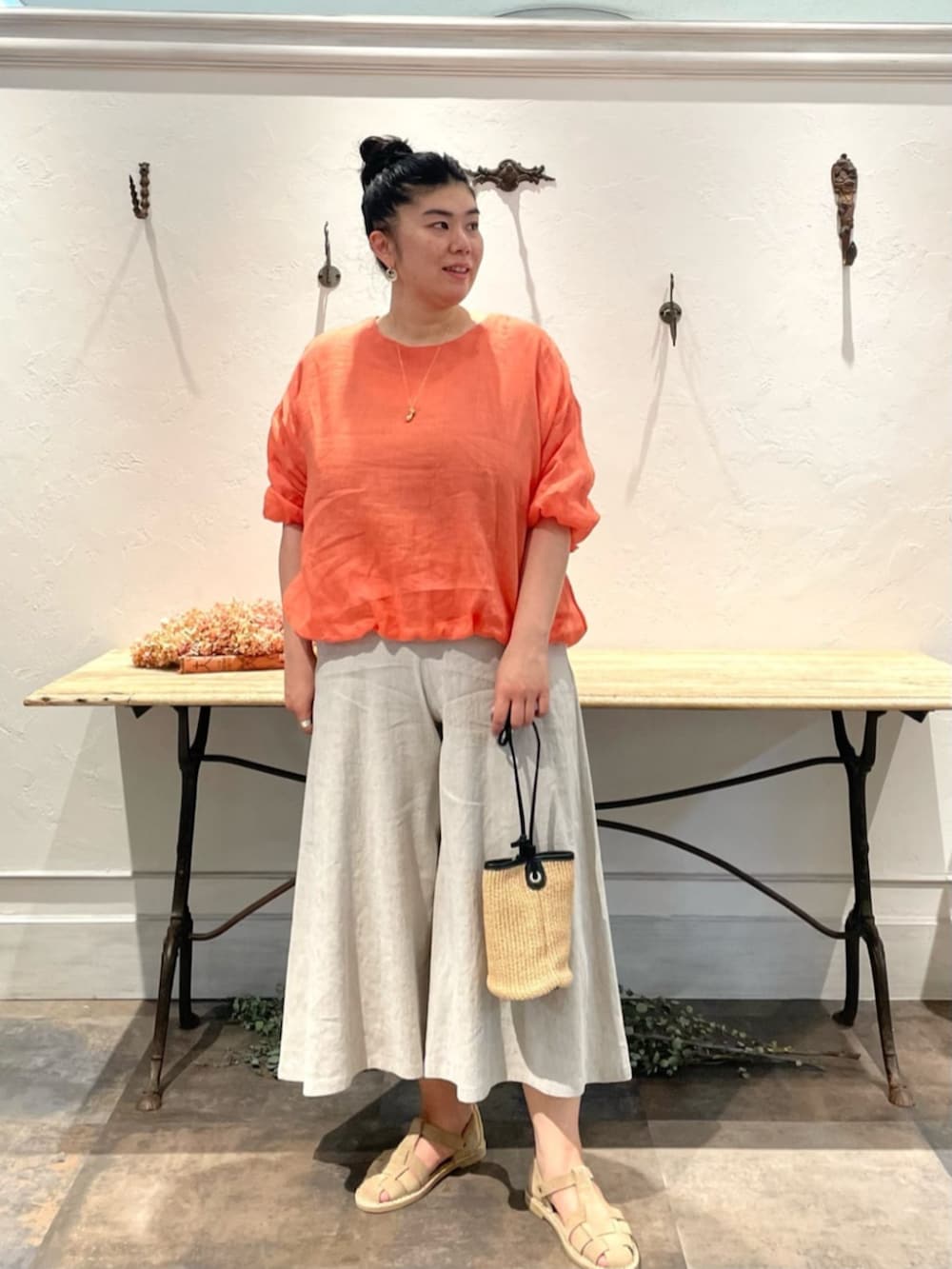 ベージュ系のその他パンツ、オレンジ系のシャツ/ブラウス、ゴールド系のリングを着用したレディースの春コーディネートの2枚目の写真
