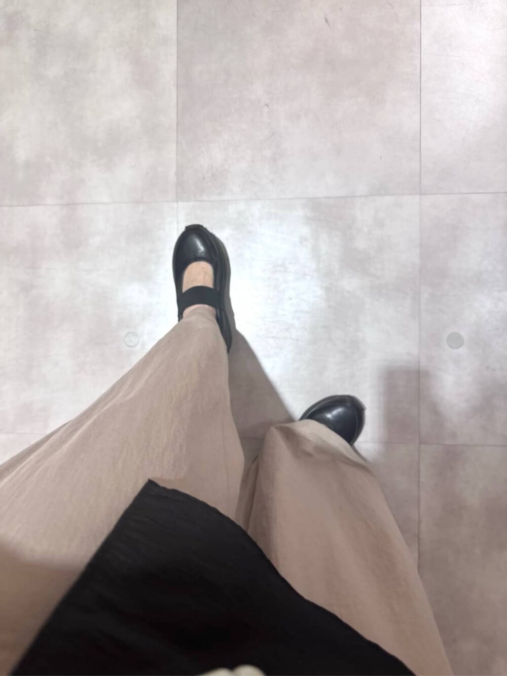 ブラック系のボストンバッグ、ベージュ系のその他パンツ、ブラック系のシャツ/ブラウスを着用したレディースの春コーディネートの10枚目の写真