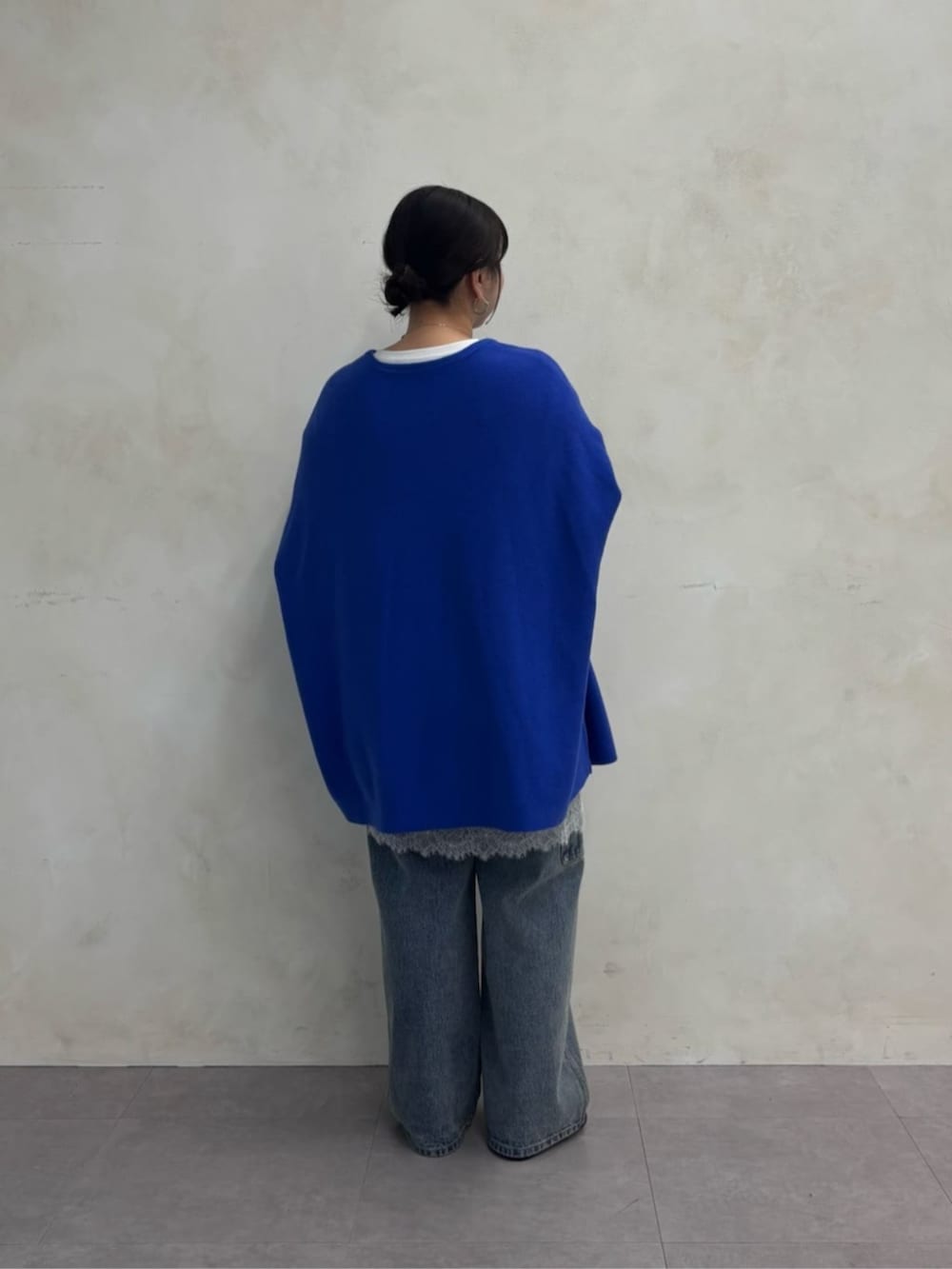 ブラック系のトートバッグ、ブルー系のデニムパンツ、ブラック系のブーツを着用したレディースの秋コーディネートの9枚目の写真