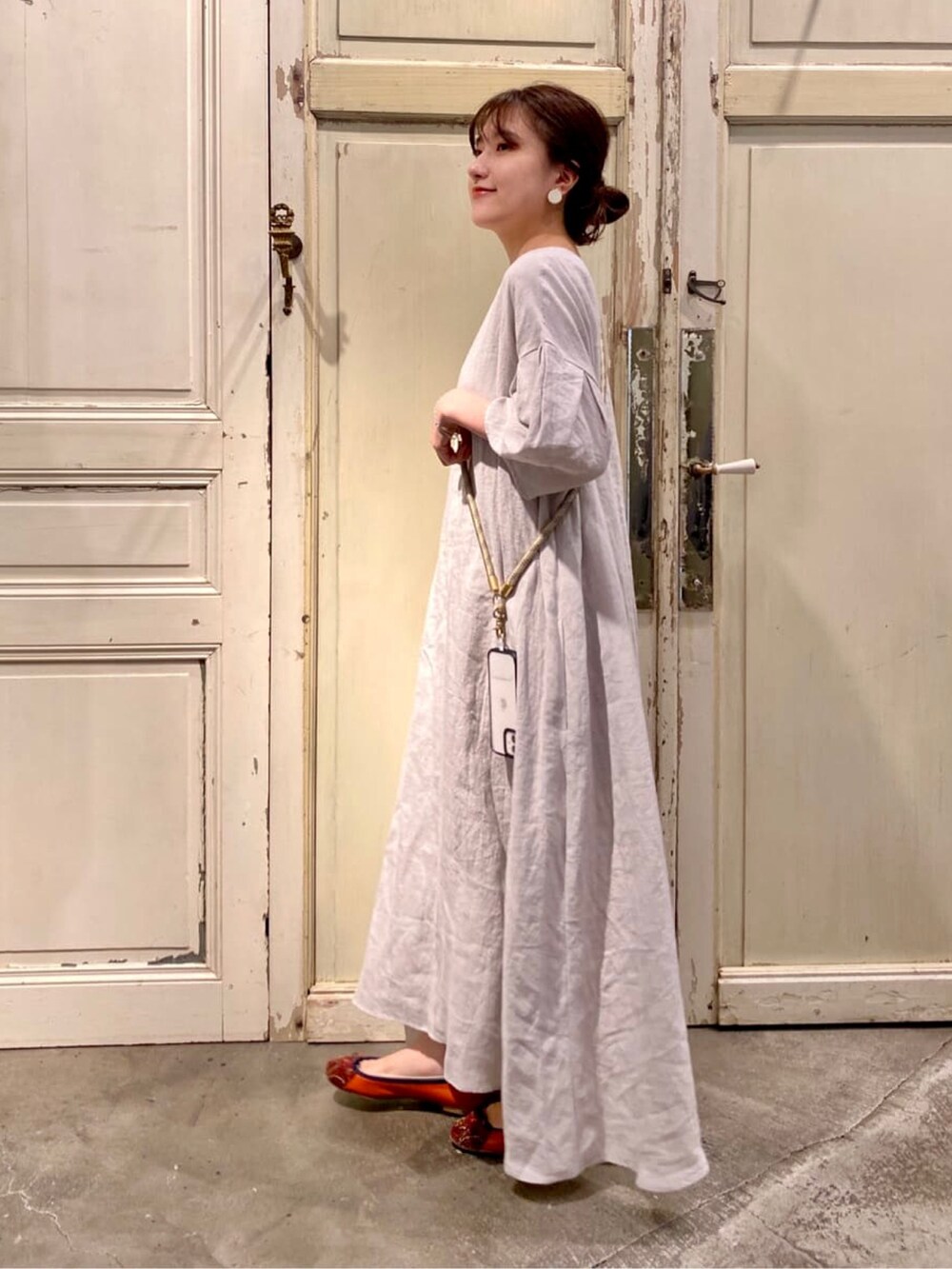 グレー系のワンピース、ベージュ系のその他小物を着用したレディースの夏コーディネートの2枚目の写真