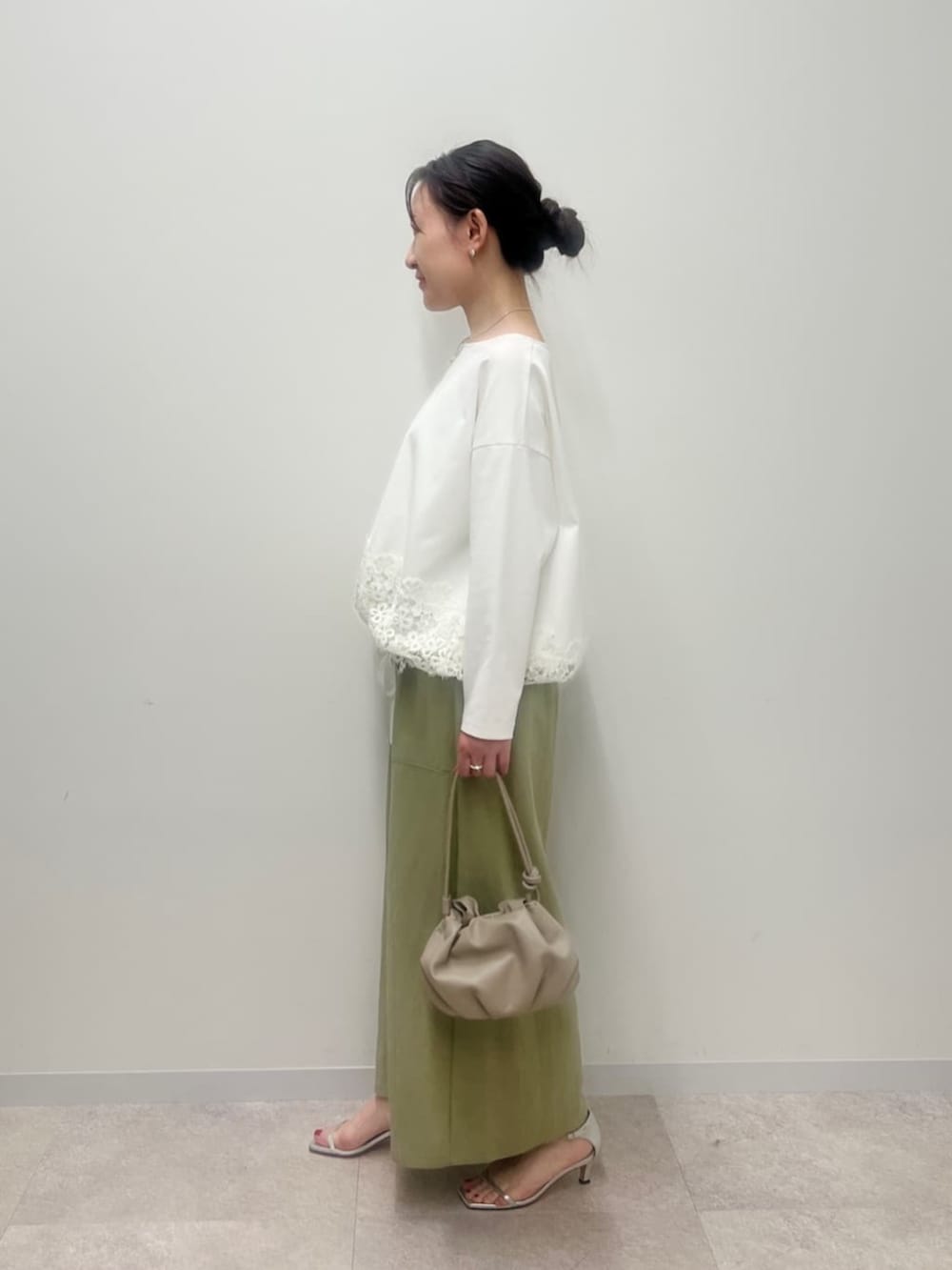 ベージュ系のショルダーバッグ、グリーン系のその他パンツ、ホワイト系のTシャツ/カットソーを着用したレディースの冬コーディネートの3枚目の写真