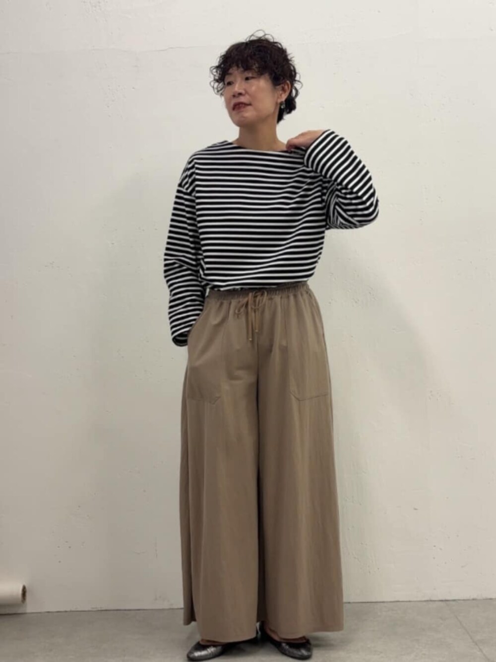 ブルー系のその他アウター、ベージュ系のその他パンツ、ブラック系のTシャツ/カットソーを着用したレディースの冬コーディネートの6枚目の写真