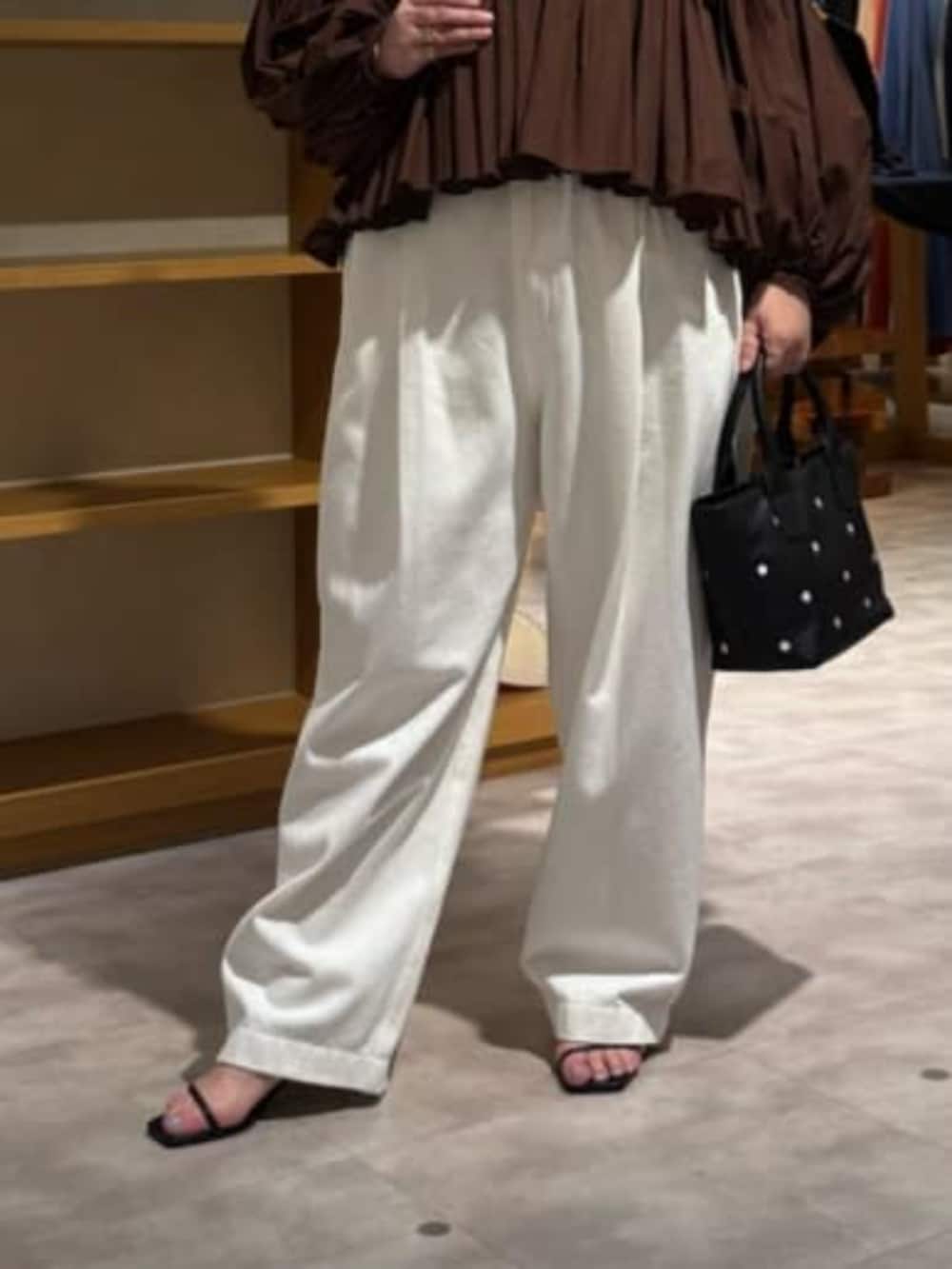 ブラック系のトートバッグ、ホワイト系のデニムパンツ、ブラウン系のシャツ/ブラウスを着用したレディースの冬コーディネートの7枚目の写真