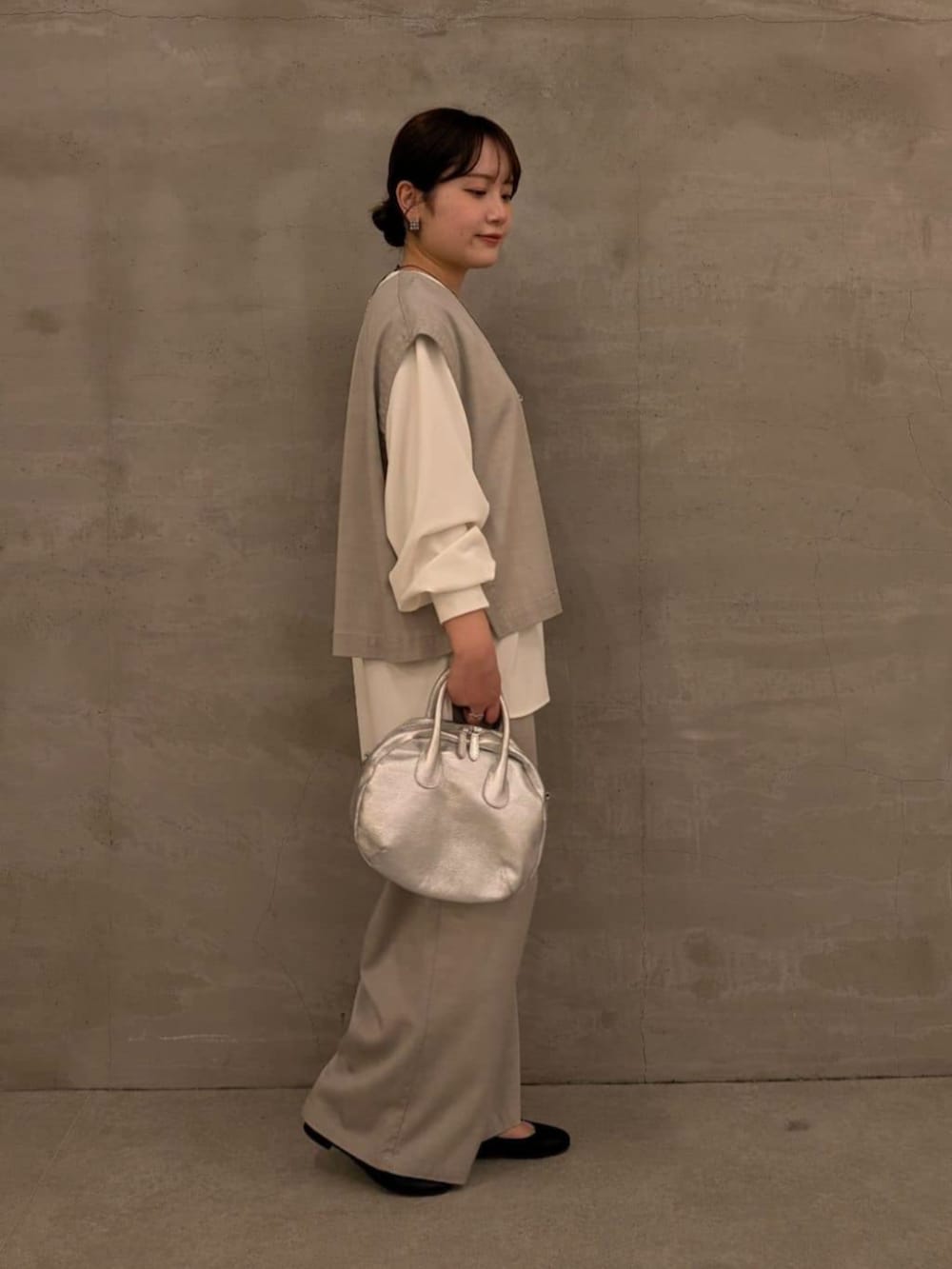 グレー系のシャツ/ブラウス、グレー系のその他パンツ、シルバー系のボストンバッグを着用したレディースの冬コーディネートの2枚目の写真