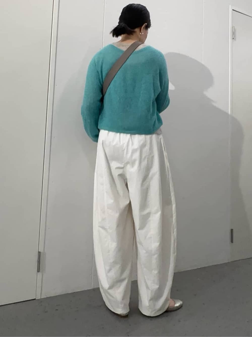 グレー系のショルダーバッグ、ブルー系のニット/セーター、ホワイト系のその他パンツを着用したレディースの夏コーディネートの4枚目の写真