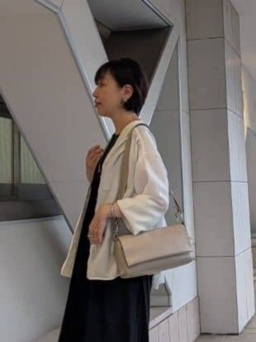 ホワイト系のシャツ/ブラウス、ブラック系のワンピース、ブラック系のスニーカーを着用したレディースの夏コーディネートの3枚目の写真